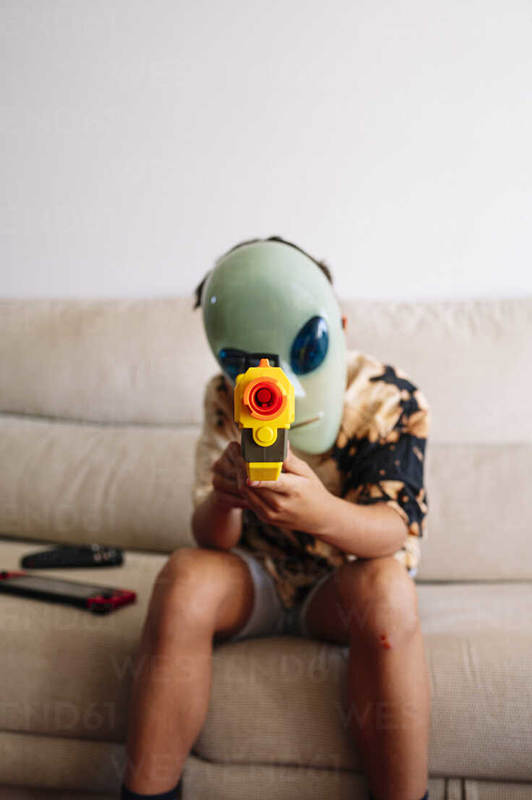 11 year old boy playing dangerous gun toys at home, Madrid Spain