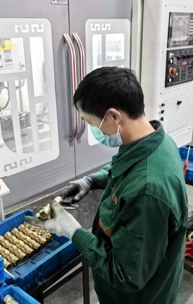 QC measuring the dimensions in production line station